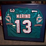 A signed Dan Marino Miami Dolphins jersey in a black picture frame