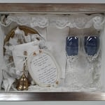 Wedding day memorabilia in a glass box with a wooden frame