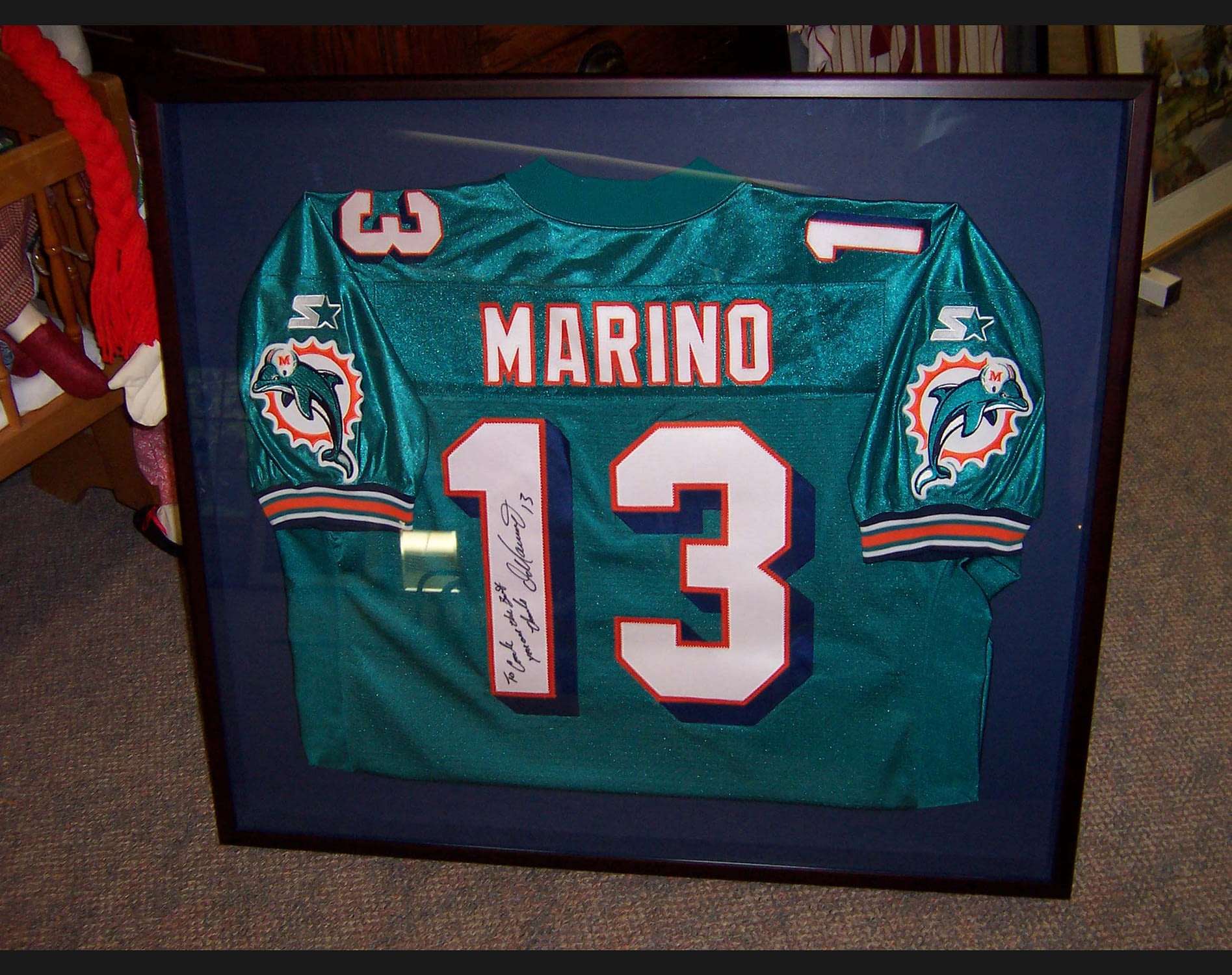 A signed Dan Marino Miami Dolphins jersey in a black picture frame
