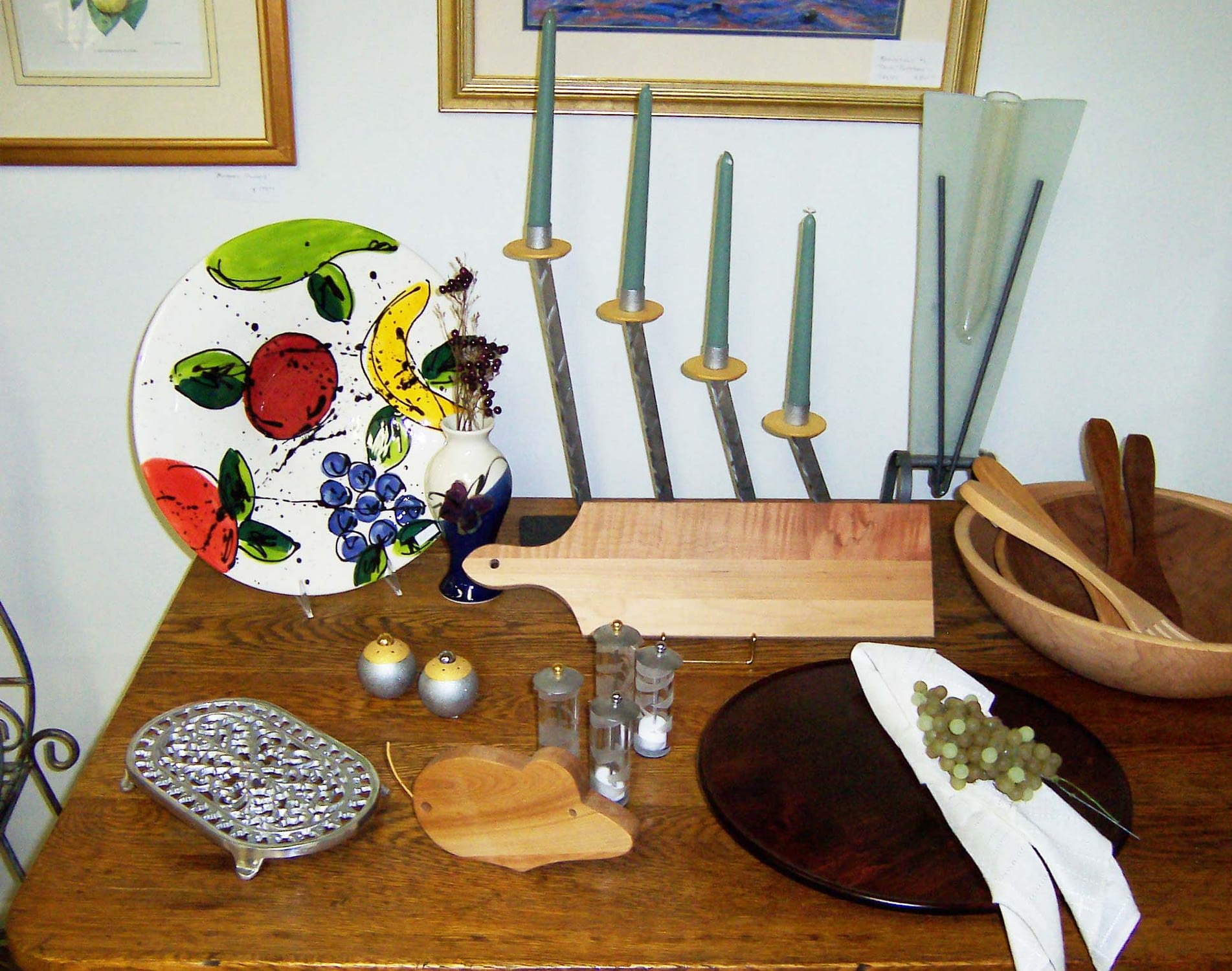 Wood table with ceramic art and wooden serving platters and utensils on top