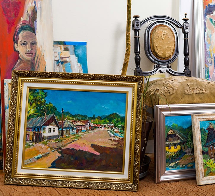 Multiple framed art pieces sitting on the floor